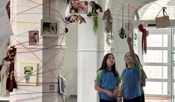 Alumnes de l'escola FEDAC Monistrol contemplant una instal·lació artística col·lectiva duta a terme a l'escola.