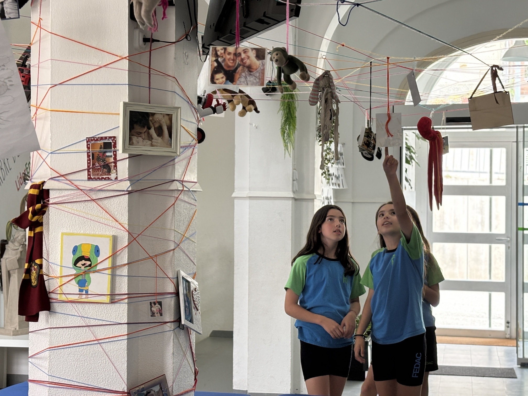 Alumnes de l'escola FEDAC Monistrol contemplant una instal·lació artística col·lectiva duta a terme a l'escola.